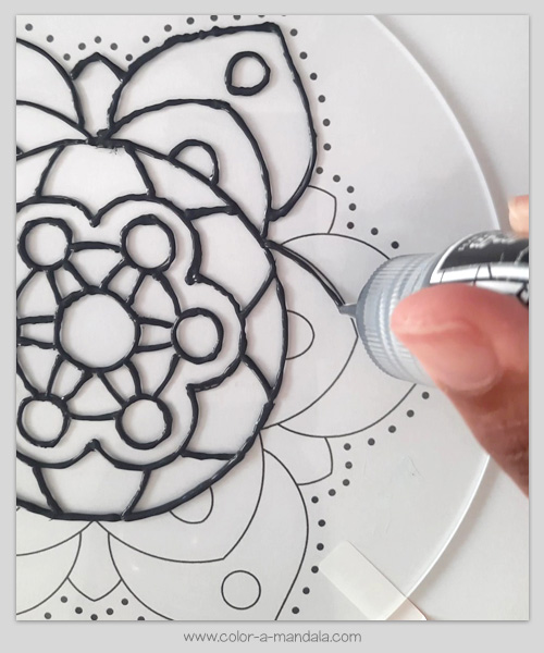 DIY Suncatcher tutorial. Use liquid leading to trace the design from the coloring page onto the plastic disk.